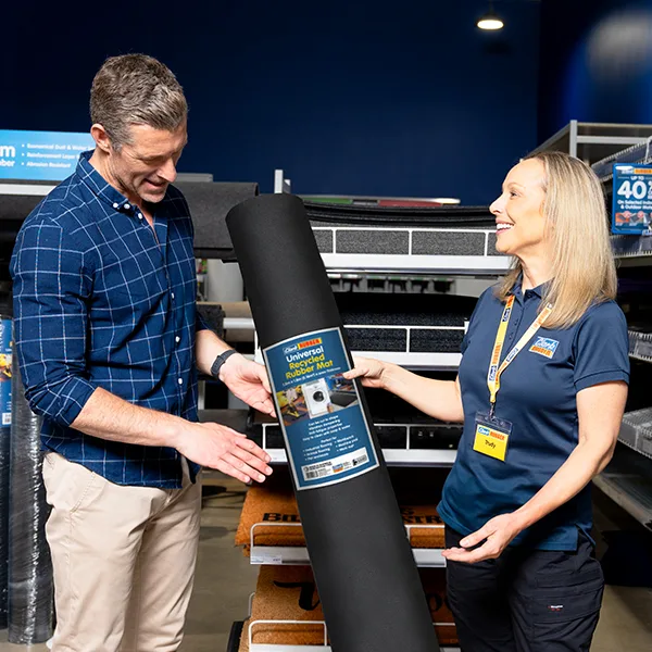 Customer speaking with Clark Rubber team member about rubber matting options. Clark Rubber team member helping a customer choose rubber matting for their laundry.