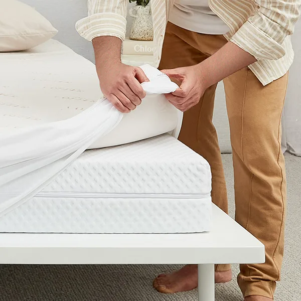 Mattress topper being placed on a bed to improve comfort