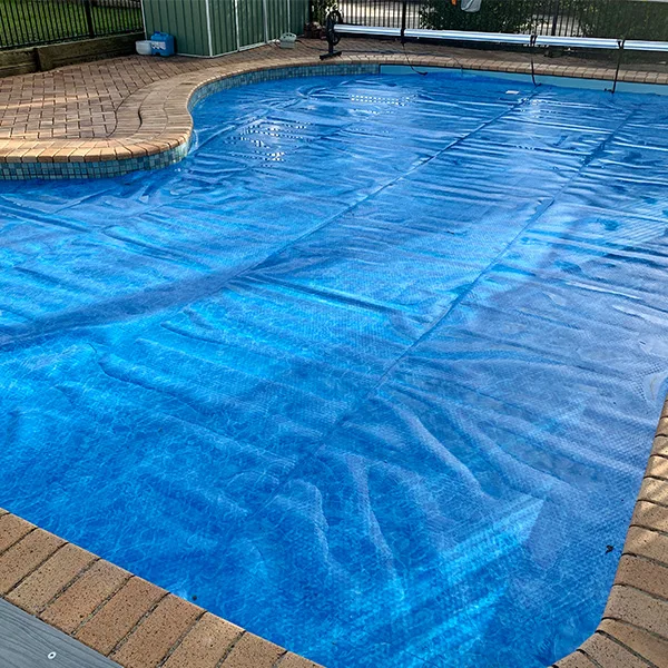 Backyard pool fitted with a protective pool cover in use